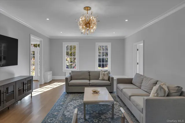 a living room with furniture a rug and a flat screen tv