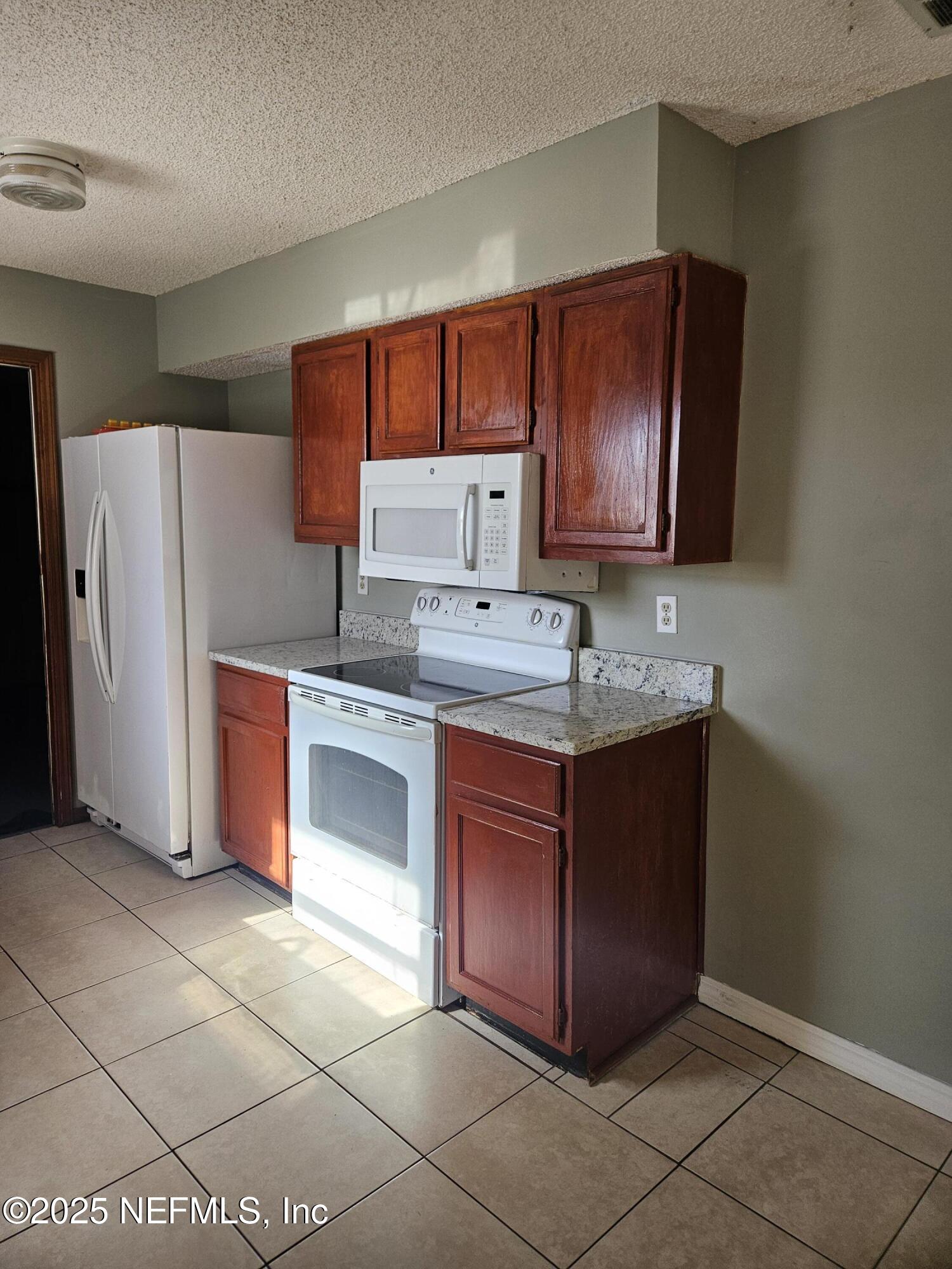 8256 Justin Road North Jacksonville, FL 32210 - Photo 21 of 35 a kitchen with stainless steel appliances granite countertop a stove a sink and a refrigerator