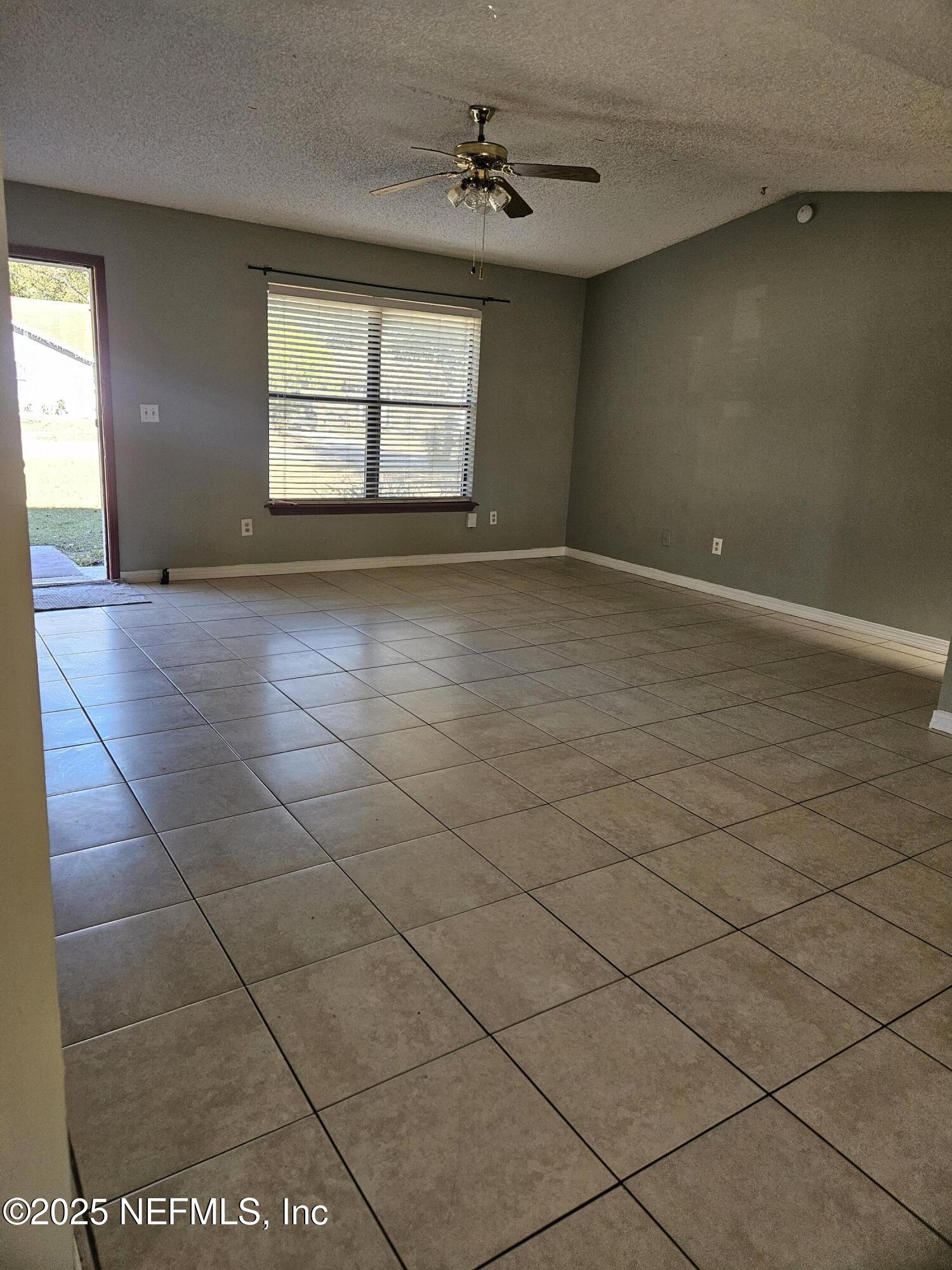 8256 Justin Road North Jacksonville, FL 32210 - Photo 26 of 35 an empty room with windows and ceiling fan