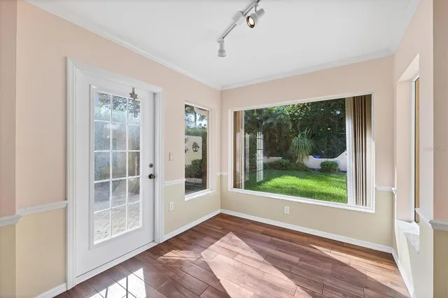 a view of a big room with windows and chandelier fan