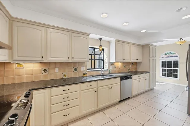 a view of an empty room with chandelier fan