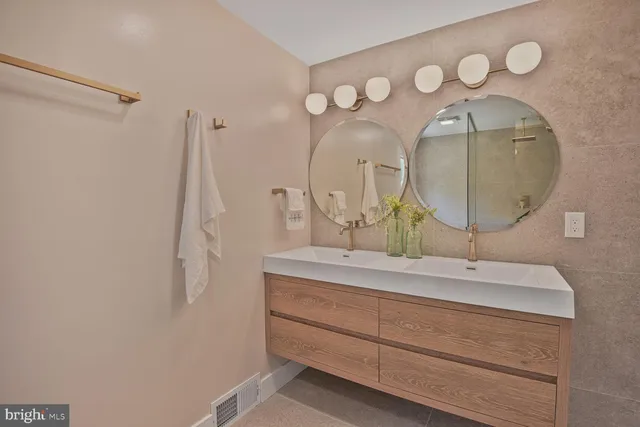 a bathroom with a double vanity sink and a mirror