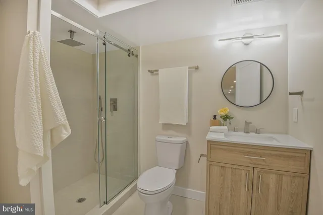 a bathroom with a toilet sink vanity and shower