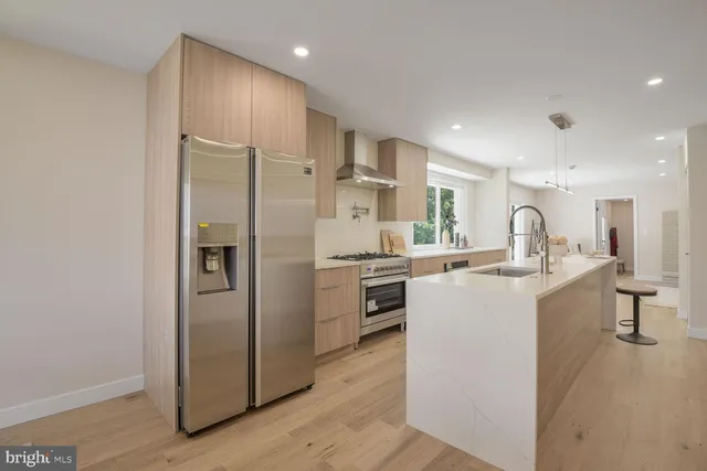 a kitchen with stainless steel appliances a refrigerator sink and stove