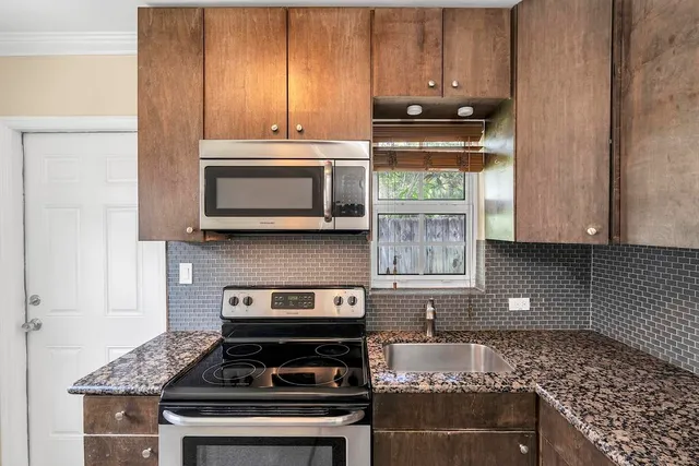 a kitchen with stainless steel appliances granite countertop a stove and a microwave