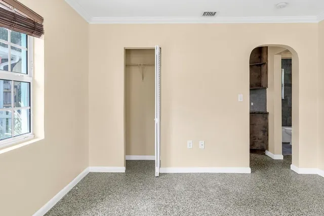an empty room with windows and closet