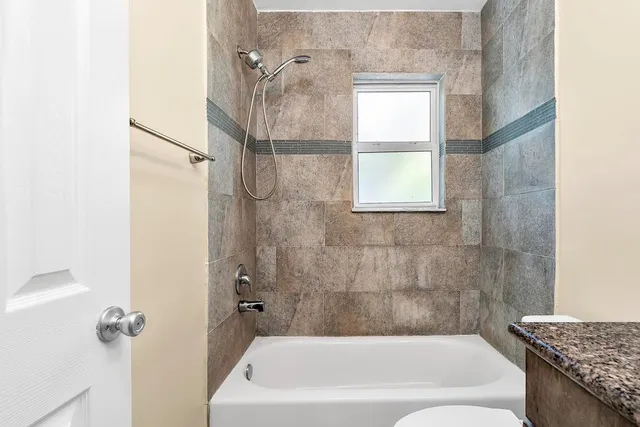 a bathroom with a granite countertop bathtub shower and a sink
