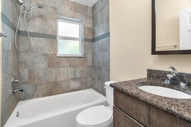 a bathroom with a granite countertop sink toilet and bathtub