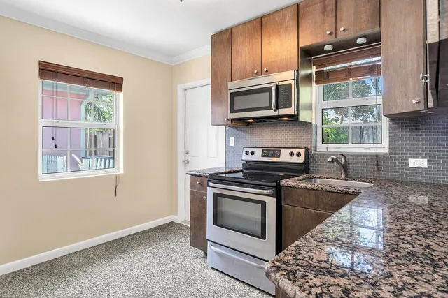 a kitchen with stainless steel appliances granite countertop a stove microwave and sink
