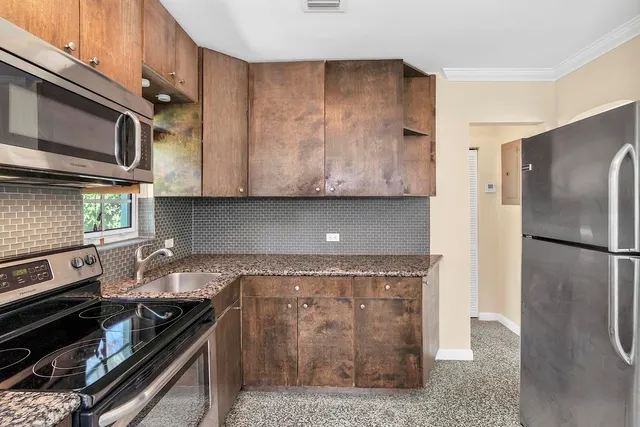 a kitchen with granite countertop a stove and a refrigerator