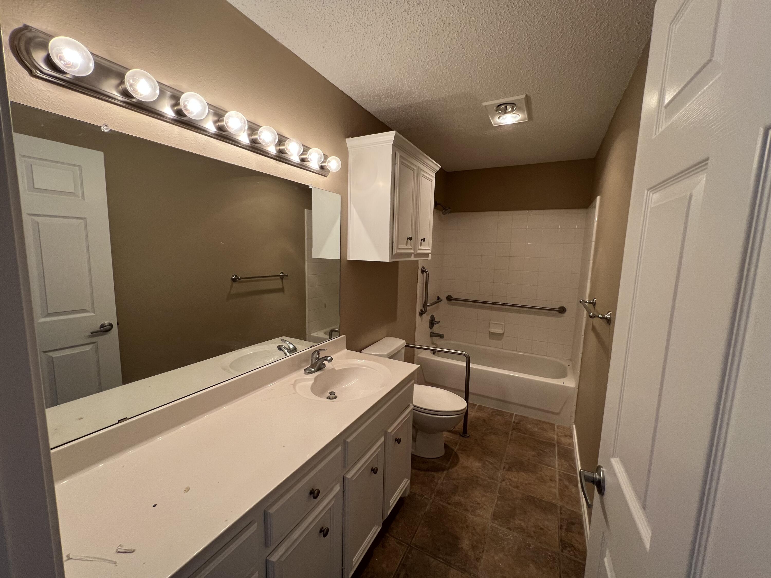 6505 8th Street Lubbock, TX 79416 - Photo 11 of 12 a bathroom with a double vanity sink mirror and toilet