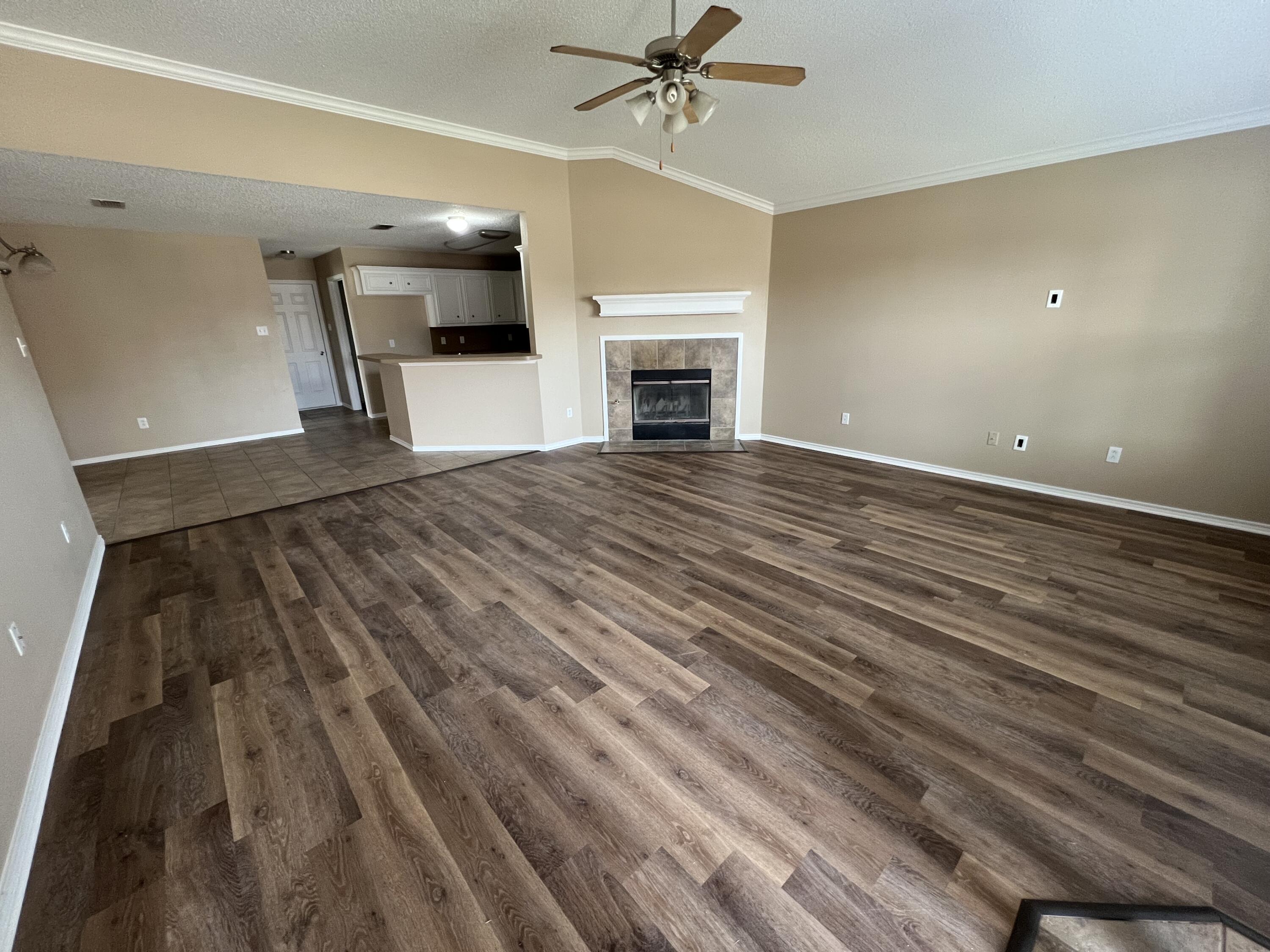 6505 8th Street Lubbock, TX 79416 - Photo 2 of 12 wooden floor in an empty room with a fireplace