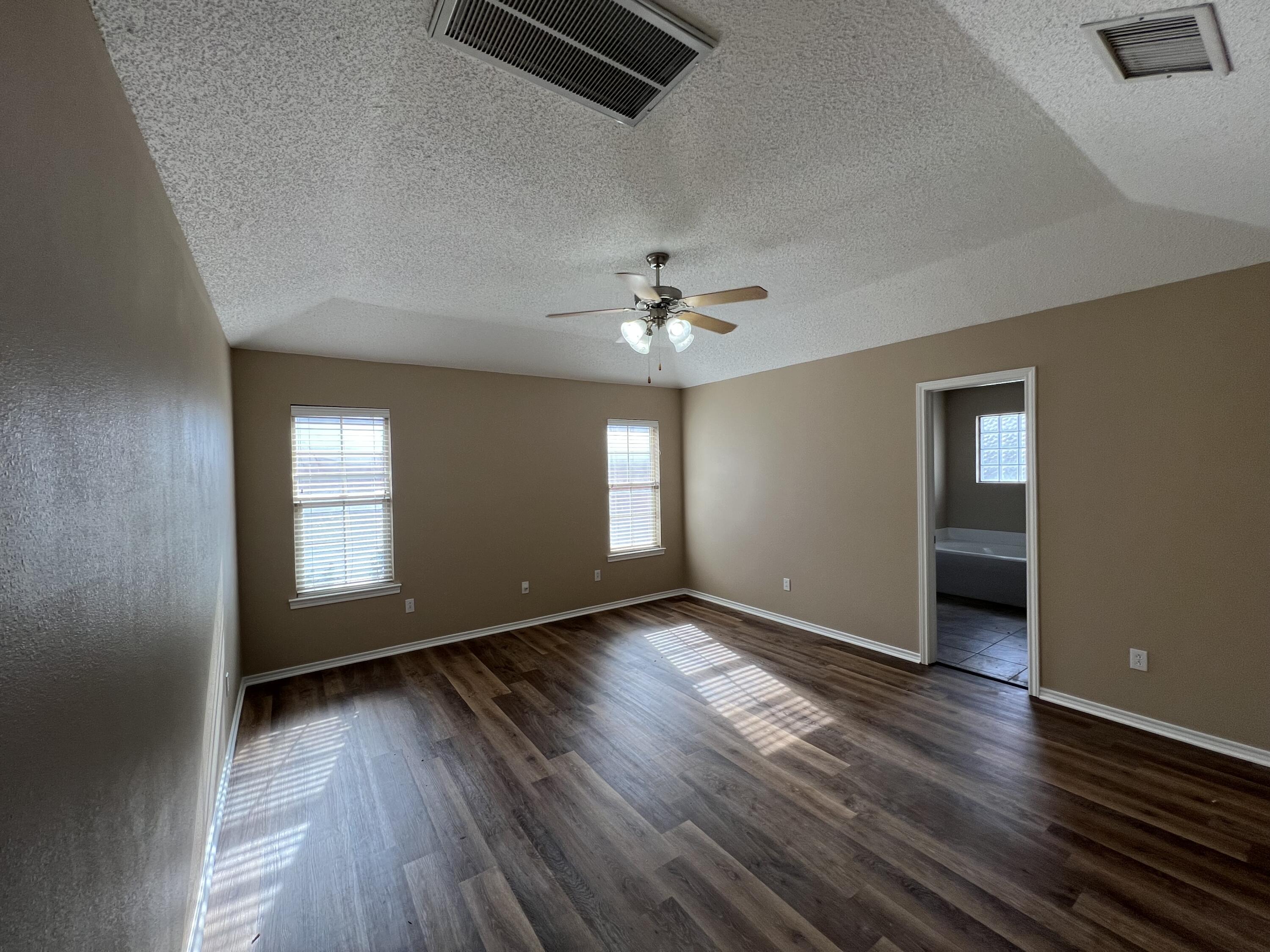 6505 8th Street Lubbock, TX 79416 - Photo 5 of 12 wooden floor in an empty room with a window