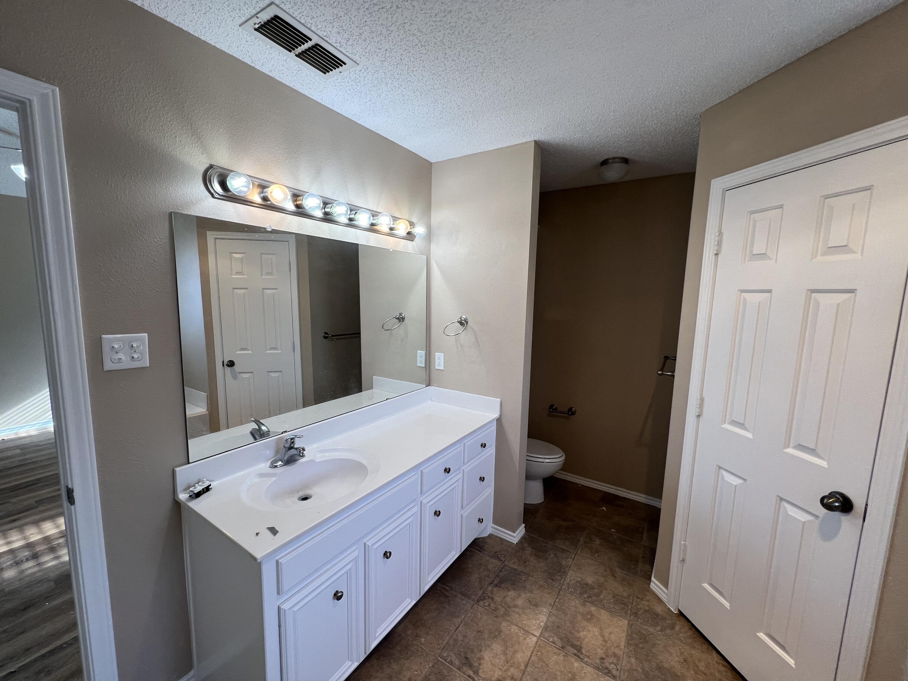 6505 8th Street Lubbock, TX 79416 - Photo 6 of 12 a bathroom with a double vanity sink and mirror