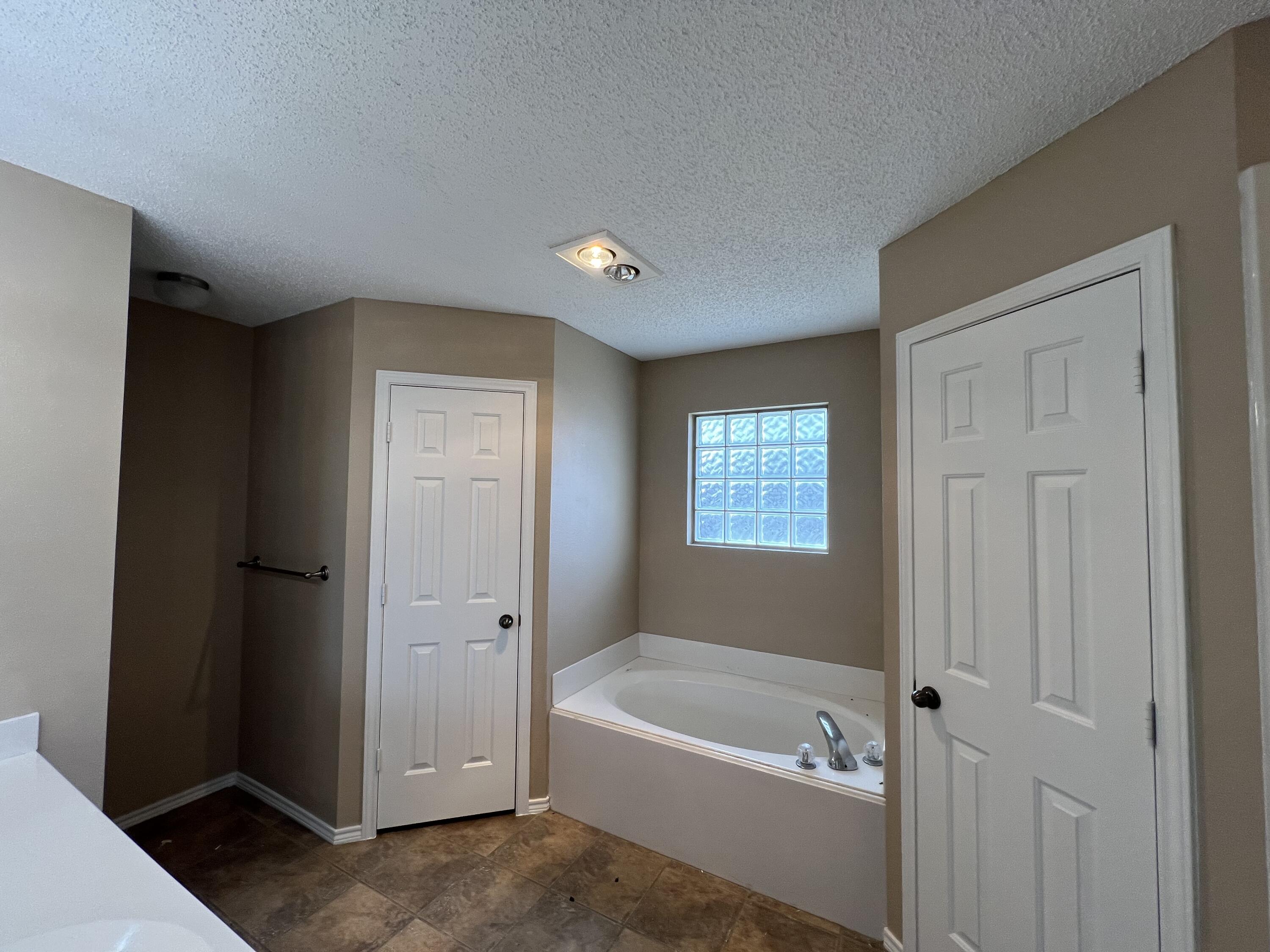 6505 8th Street Lubbock, TX 79416 - Photo 7 of 12 a bathroom with a tub shower and closet