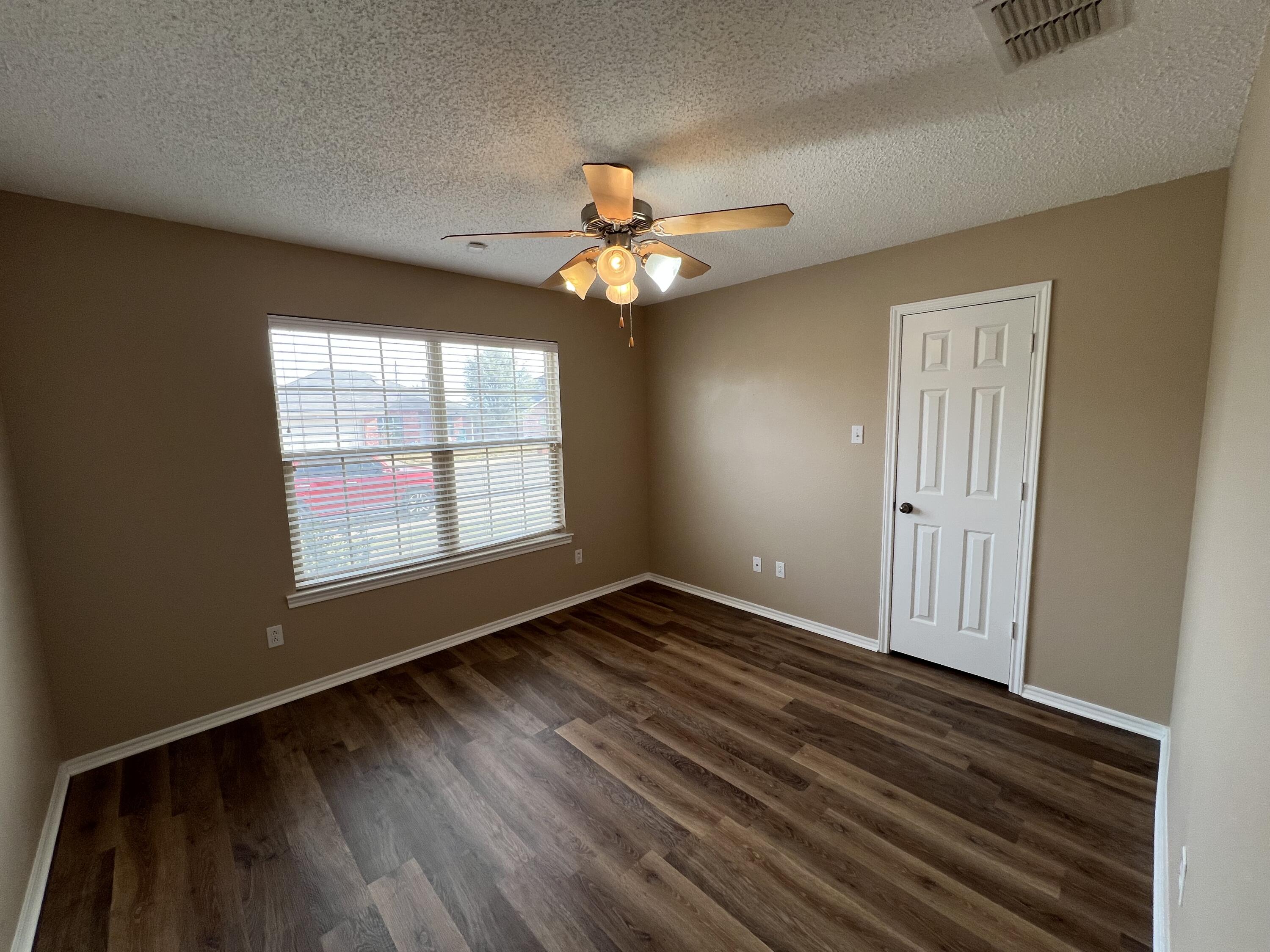 6505 8th Street Lubbock, TX 79416 - Photo 9 of 12 a view of an empty room with window and wooden floor