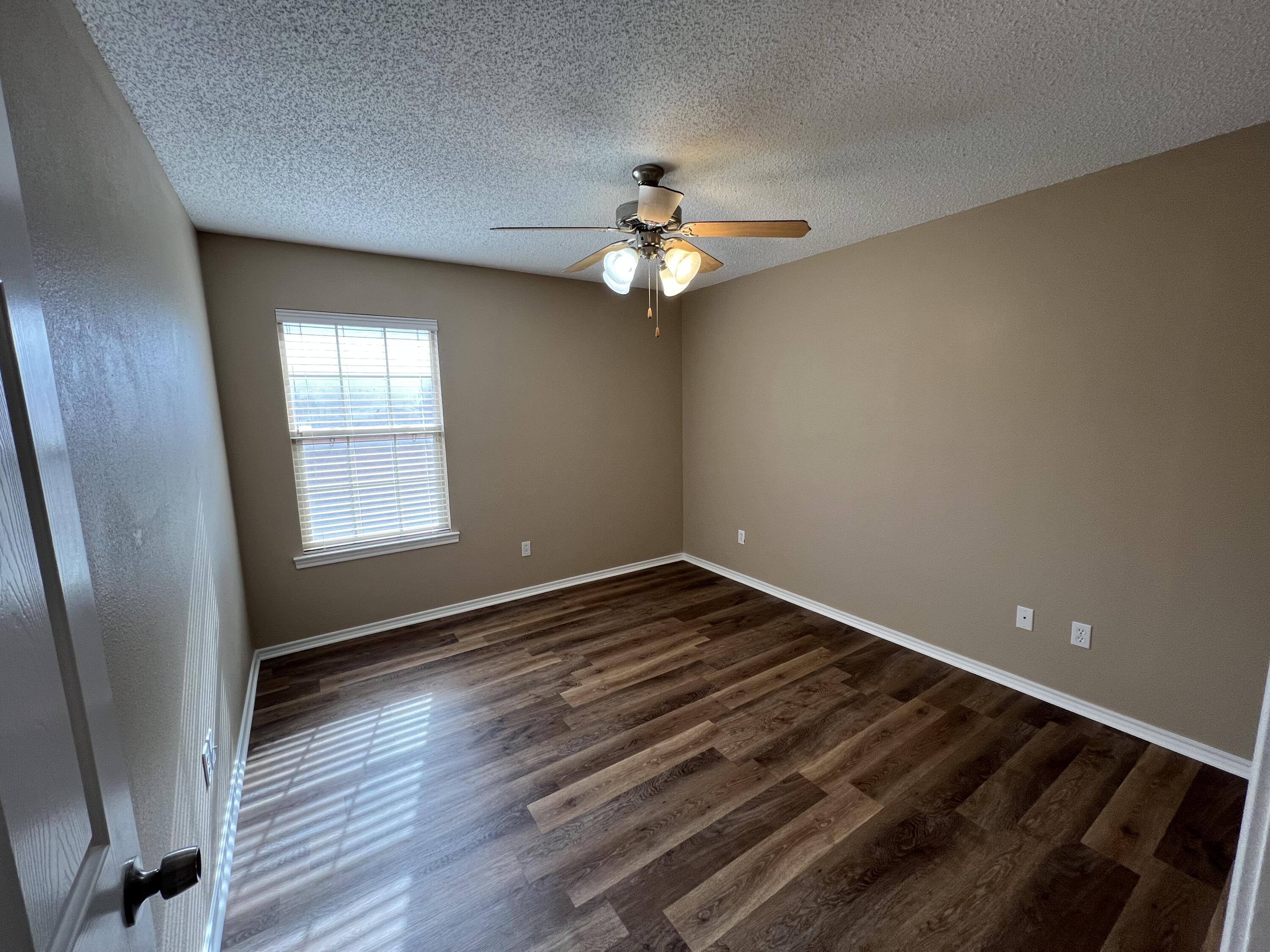 6505 8th Street Lubbock, TX 79416 - Photo 10 of 12 wooden floor in an empty room with a window