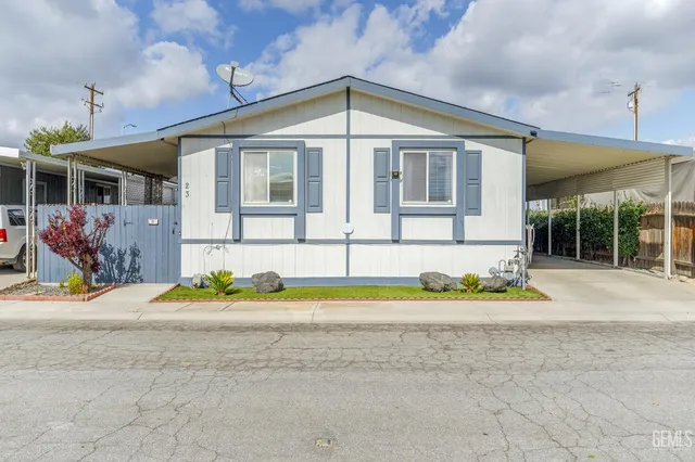 a front view of a house with a yard and potted plants