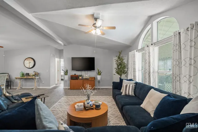 a living room with furniture a flat screen tv and a large window