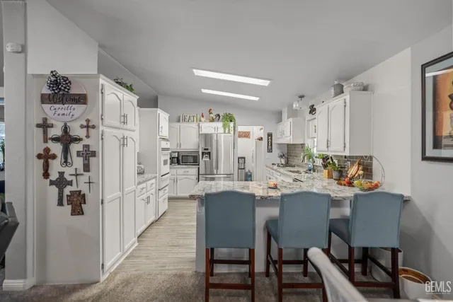 a kitchen with stainless steel appliances a table chairs and a refrigerator