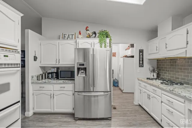 a kitchen with stainless steel appliances a refrigerator sink and cabinets