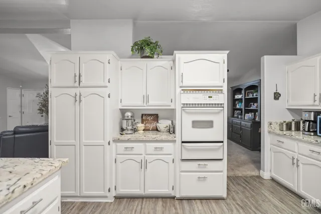 a kitchen with white cabinets and refrigerator