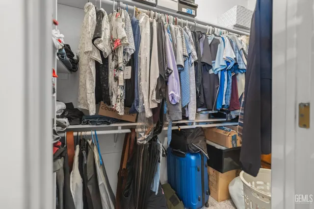 a view of walk in closet with clothes