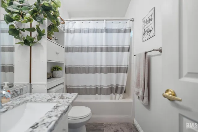 a bath room with a sink toilet and shower