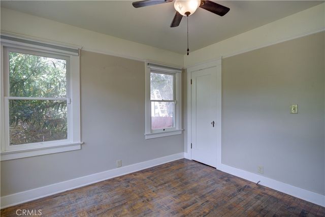 an empty room with a window and ceiling fan