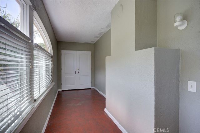 a view of a hallway with wooden floor and windows