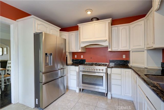 a kitchen with stainless steel appliances granite countertop a refrigerator stove and sink