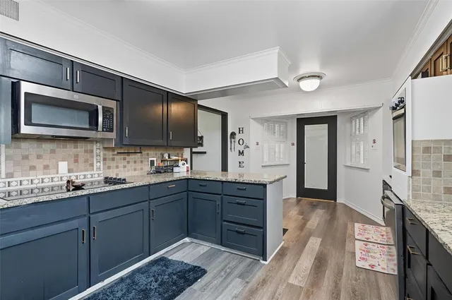 a kitchen with stainless steel appliances granite countertop a sink stove and microwave