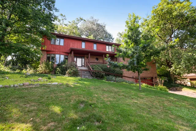a view of a house with a big yard plants and large trees