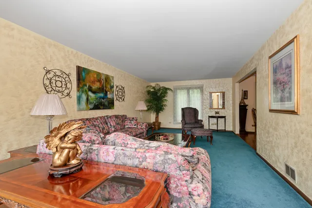 a bedroom with a bed and dresser with chair