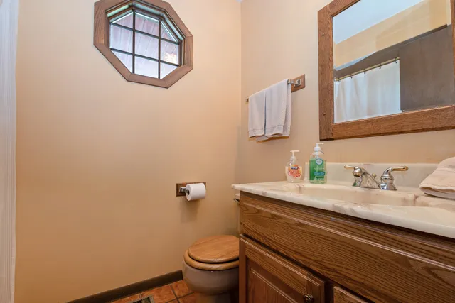 a bathroom with a granite countertop toilet sink and mirror
