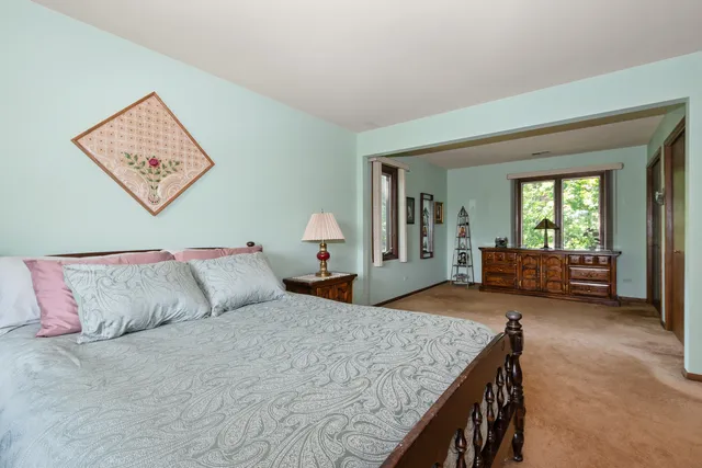 a bedroom with a large bed and a chandelier