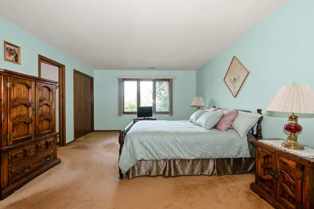 a bedroom with a bed and dresser with mirror