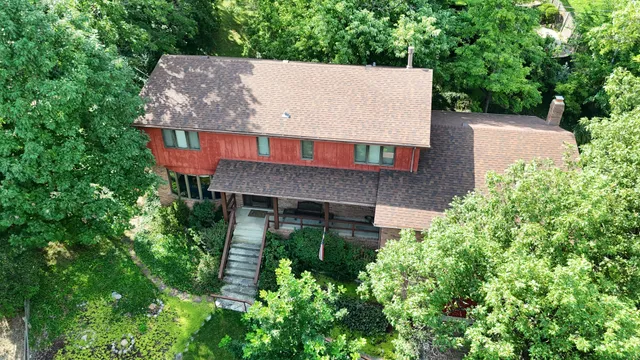 an aerial view of a house with a yard and large trees