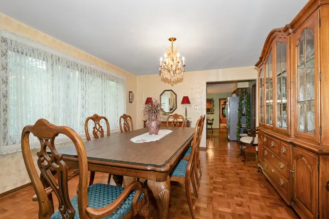a dining room with furniture a chandelier and wooden floor