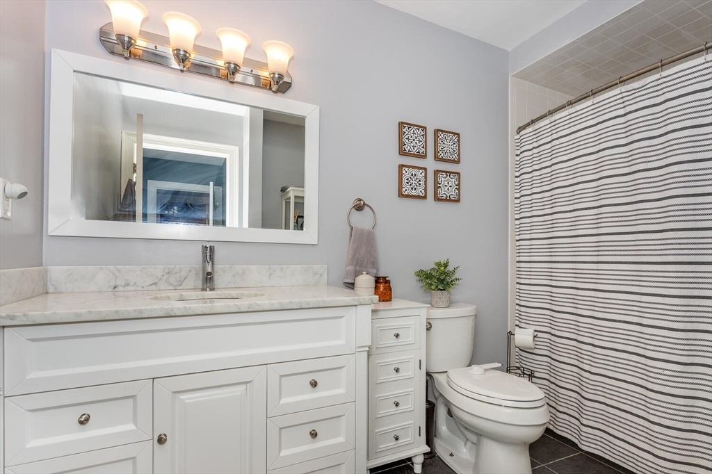 10 Forge Pond, Unit A Canton, MA 02021 - Photo 8 of 17 a bathroom with a granite countertop toilet sink and mirror