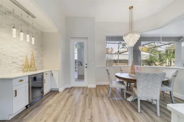 a view of a dining room and livingroom with furniture wooden floor a chandelier
