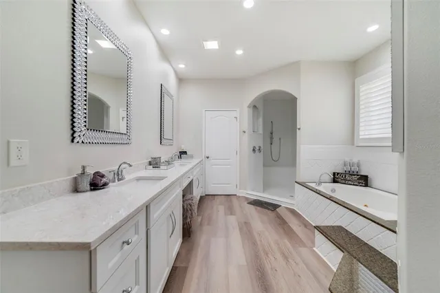 a spacious bathroom with a double vanity sink a mirror and shower