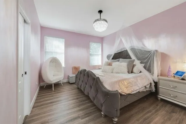 a spacious bedroom with a bed and wooden floor