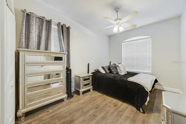 a bedroom with a bed and a ceiling fan