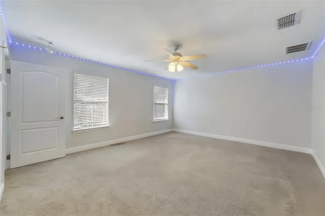 an empty room with a window and a ceiling fan