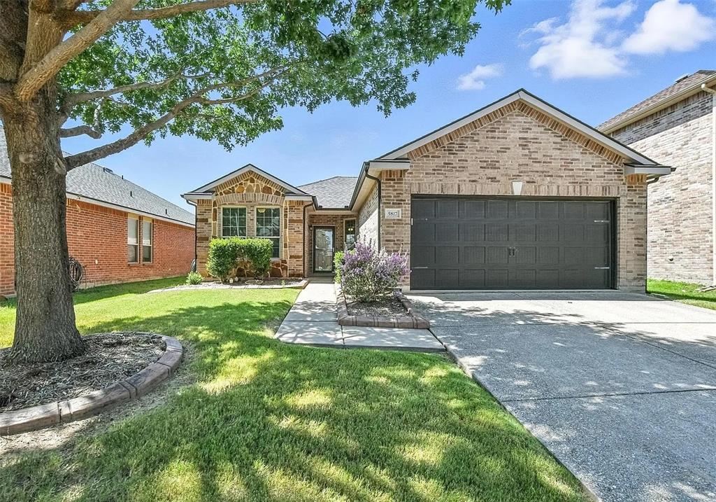 5817 Deck House Road Fort Worth, TX 76179 - Photo 2 of 19 Brick and stone exterior featuring an attached two-car garage, concrete driveway, and established front landscaping