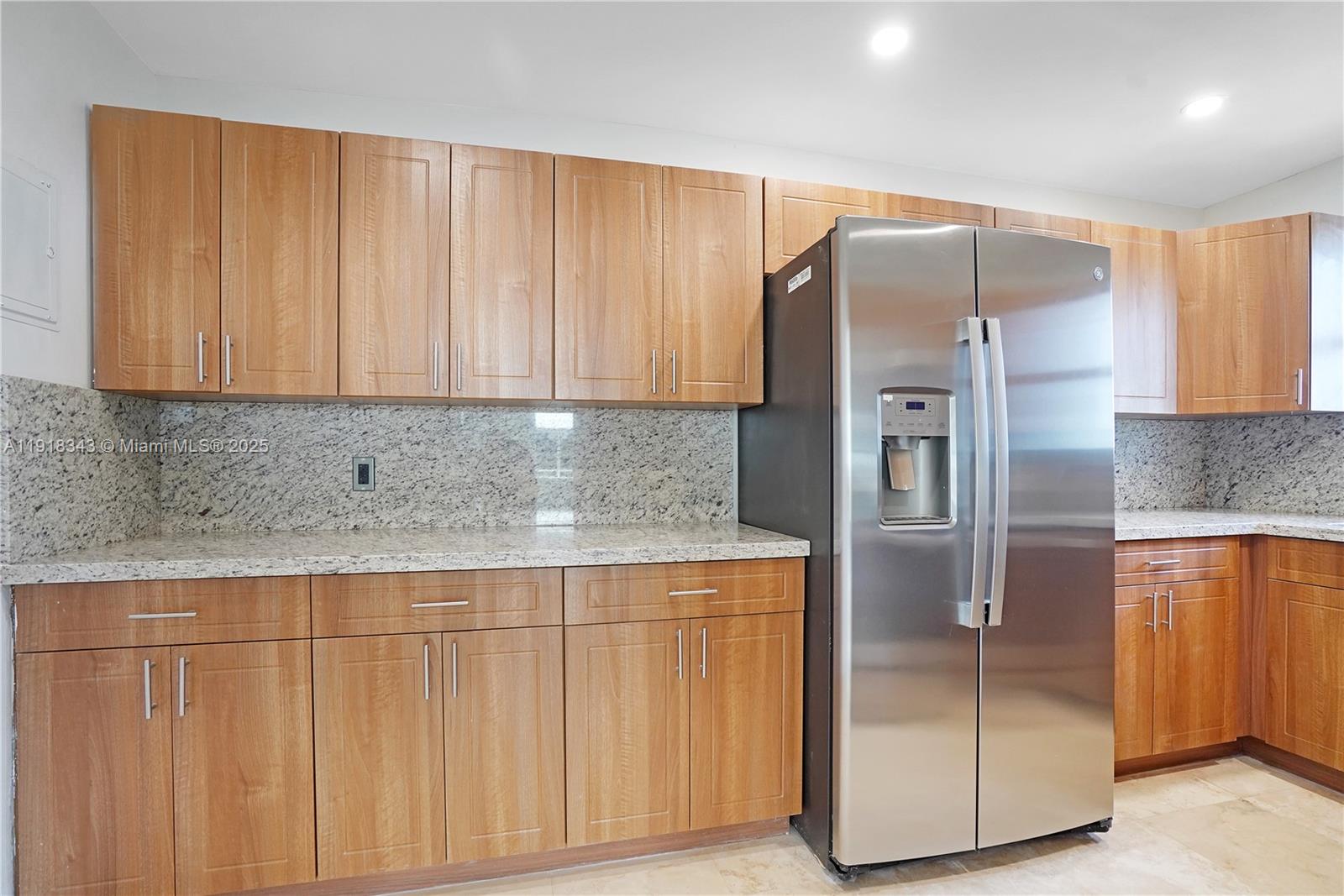 5101 Collins Avenue, Unit 14K Miami Beach, FL 33140 - Photo 11 of 13 a kitchen with stainless steel appliances granite countertop a refrigerator and a sink