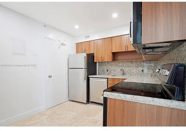 a kitchen with a refrigerator sink and cabinets