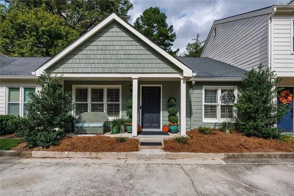 a front view of a house with a yard and potted plants