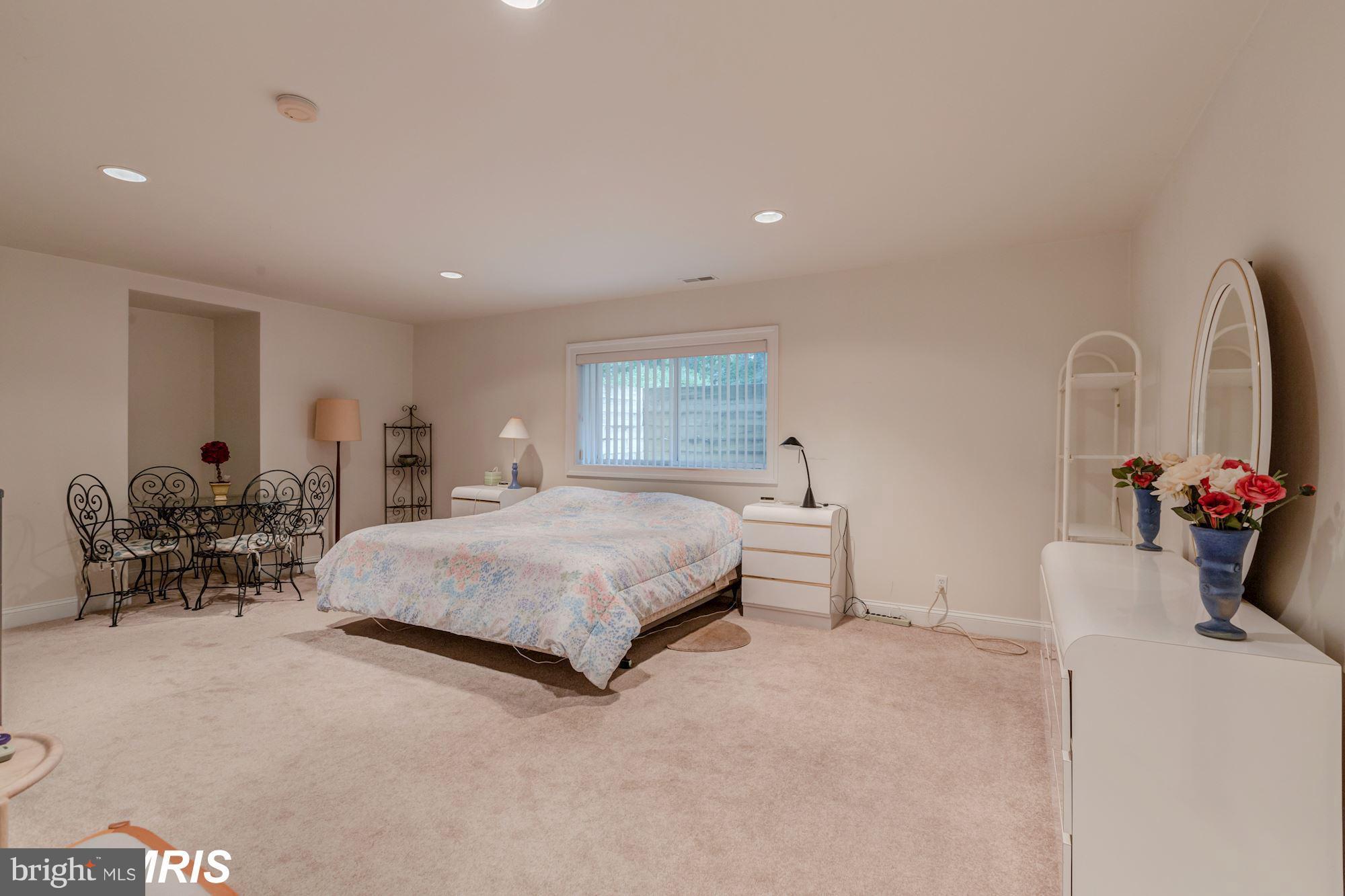 6900 Rannoch Road Bethesda, MD 20817 - Photo 14 of 22 a spacious bedroom with a bed a table and a couch